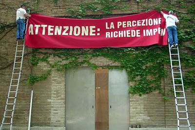 Fachada del pabellón español en la Bienal de Venecia, con el cartel: 'Atención, la percepción requiere compromiso'.