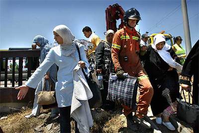 Bomberos y personal sanitario ayudaron a los inmigrantes a abandonar la zona del accidente.rnrn rnrn CARLES FRANCESCrnrnLa parte delantera del autobús quedó destrozada.