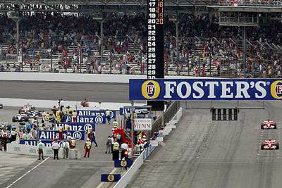 Los dos coches de Ferrari, a la derecha, en carrera, con el resto de vehículos en los  boxes. 