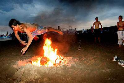 Un joven salta por encima de una de las hogueras, anoche, en la playa de la Malva-rosa.