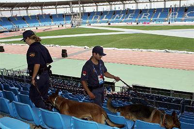 Dos policías con perros revisan las gradas del estadio de los Juegos Mediterráneos.
