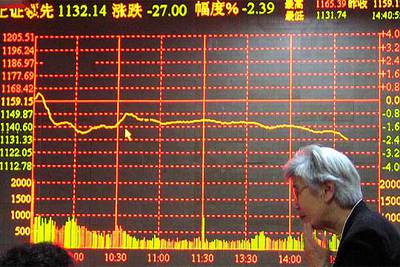 Un inversor chino en Shanghai, ante un tablero electrónico que muestra las cotizaciones de la Bolsa.