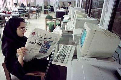 Una periodista iraní lee un diario en la redacción de un periódico reformista en Teherán.
