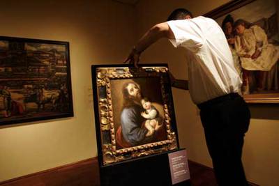 Un técnico coloca la pintura  San José con el Niño,  de Zurbarán.