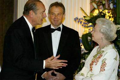 Jacques Chirac (izquierda) conversa con la reina Isabel II observado por un sonriente Tony Blair.