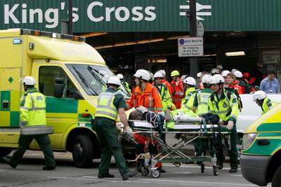 Los servicios de rescate y los servicios médicos evacuan a un herido de la estación de metro de King's Cross.