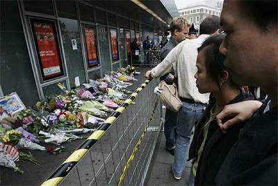 La gente observa los improvisados tributos florales dejados en las afueras de la estación de King's Cross.