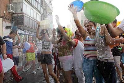 Vecinos de Vallecas se remojan durante la  batalla naval  celebrada ayer por las calles del distrito.