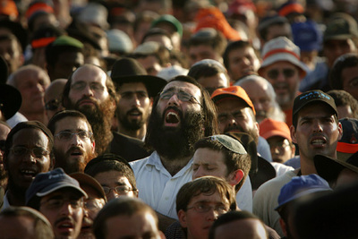 Los colonos opuestos a la retirada de los asentamientos de Gaza rezan antes de iniciar la marcha de protesta.