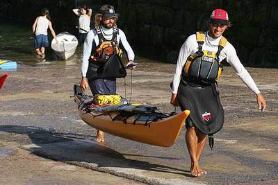 Etxeberria (a la derecha) y Erkiaga llegan ayer al puerto de San Sebastián y portan la  kayak  de mar con la que han dado la vuelta a la península.