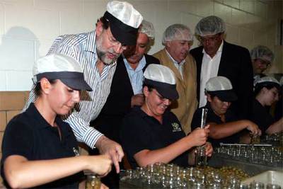 De izquierda a derecha, Rajoy, Arenas y el alcalde de Morón, Manuel Morilla, en una envasadora de aceitunas.