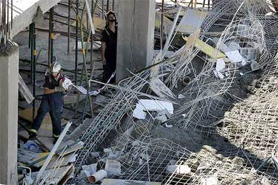 Dos bomberos inspeccionan el estado en el que quedó la estructura de la obra tras el derrumbe.