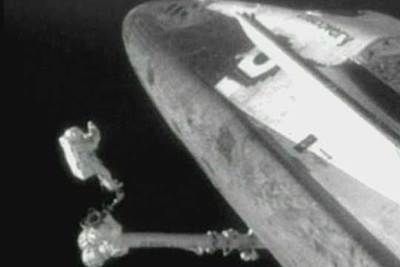 Steven Robinson, sujeto al brazo robótico de la estación, durante la reparación del  Discovery. 