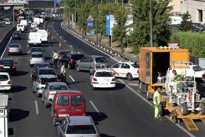 Unos operarios (a la derecha) concluyen el pintado del punto de la A-2 donde se produjo el atasco.