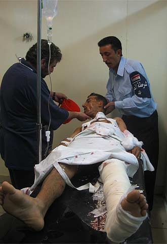 Un policía iraquí ayuda a un doctor a atender a un agente herido ayer.