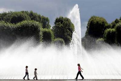 Unos niños disfrutan de una jornada veraniega frente a una fuente.