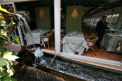 Comedor del restaurante-sidrería El Oso, en Madrid. Abajo, un plato de  pixín  (rape).