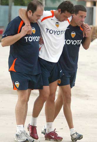 Edu, con dos fisioterapeutas, tras lesionarse.