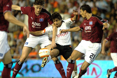 Aimar trata de llevarse la pelota entre dos defensores del Hamburgo.