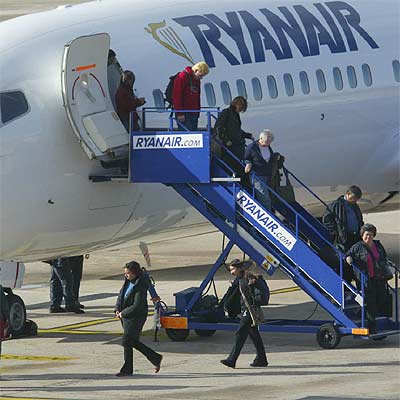 Un grupo de pasajeros desciende de un avión de Ryanair en el aeropuerto de Girona, su principal centro de operaciones en España.