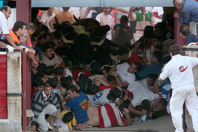 Decenas de corredores quedan atrapados a la entrada de la plaza mientras los toros intentan pasar por encima de ellos.