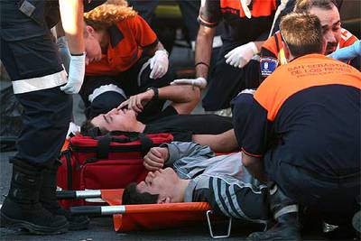 Efectivos sanitarios atienden a dos de los contusionados en el encierro.rnrn SANTI BURGOSrnrnUna joven habla por el móvil y llora por lo ocurrido en el coso.