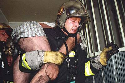 Un bombero evacua a un residente del edificio incendiado en L'Hay-les-Roses, al este de París.
