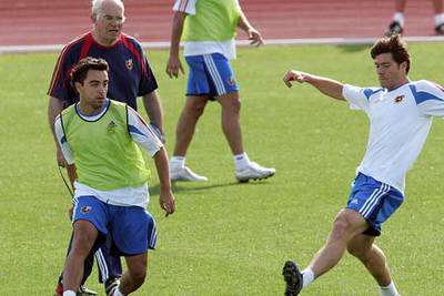 Luis observa cómo Xavi envía un centro, en el entrenamiento de ayer, superando a Xabi Alonso.