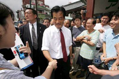 El líder del Partido Demócrata de Japón, Katsuiya Okada, estrecha la mano de sus simpatizantes ayer en Tokio.