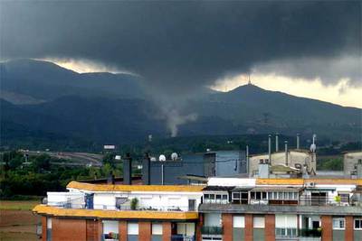 El tornado, captado ayer desde un edificio de Mollet del Vallès.rnrnEste coche fue arrastrado hasta el mar desde una riera de Montgat.