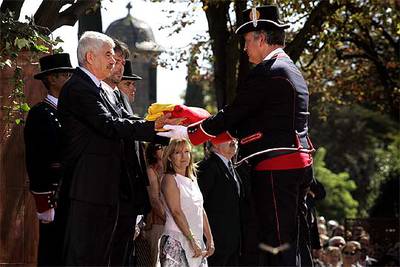 El presidente Pasqual Maragall entrega la  senyera  para que los Mossos d'Esquadra la izen, en el parque de la Ciutadella.