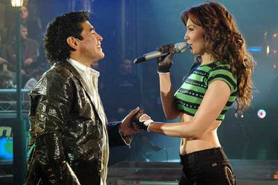 El ex futbolista argentino Diego Armando Maradona canta a dúo con la cantante mexicana Thalia, durante el programa de televisión  La noche del Diez , que conduce el antiguo jugador.