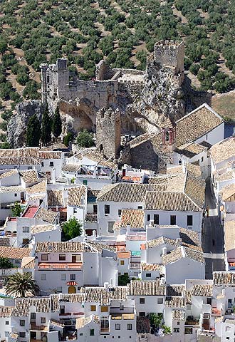 Zuheros se extiende con sus casas blancas y su enjambre de callejuelas al pie del peñón que ocupa su castillo.
