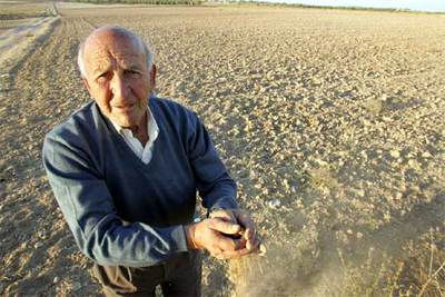 Un hombre muestra la tierra seca en Villamanrique de Tajo.