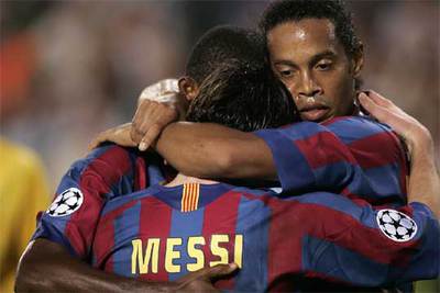 Ronaldinho y Eto'o se abrazan con Messi tras un gol del primero.