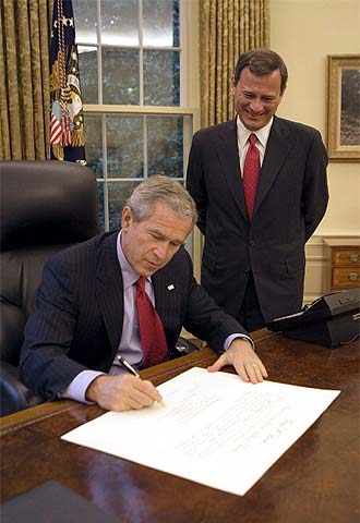 George Bush firma el acta de nombramiento de John Roberts.