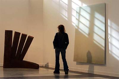 Un visitante observa la obra   Asedio,   a la izquierda, de Patxi Gutiérrez.