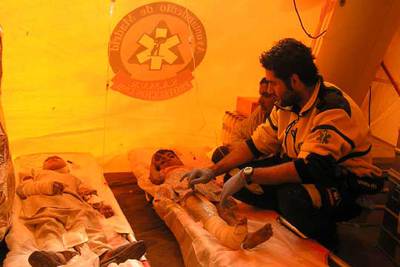 El médico Iván Barrientos atiende a la niña con el muslo fracturado junto a un traductor.