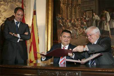 Camps sonríe mientras observa a Giner y a García Antón intercambiarse el convenio firmado.