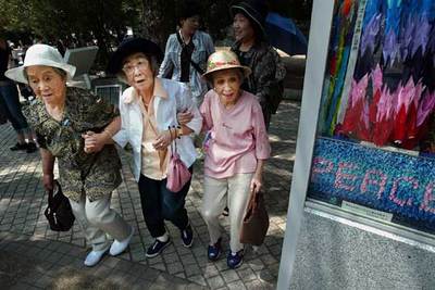 Tres mujeres japonesas se apoyan al entrar en el Parque de la Paz en Hiroshima el pasado verano.