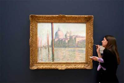 Una empleada retoca el marco de  El Gran Canal,  de Monet, la estrella de la subasta de Sotheby's.