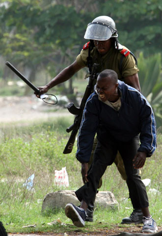 Un policía se lleva detenido a un militante de la oposición.