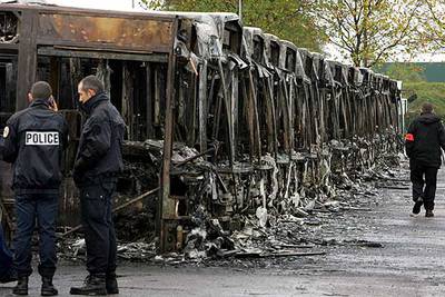 Un grupo de policías busca pistas en las cocheras de autobuses urbanos de Trappes, en las afueras de París, donde 27 vehículos fueron incendiados.