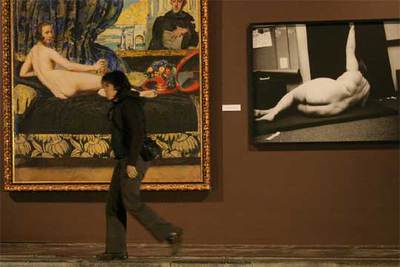 Una visitante camina ante  Desnudos de espaldas,  de Ortiz Echagüe y  Showground,  de Paul Kooiker, ayer en San Sebastián.