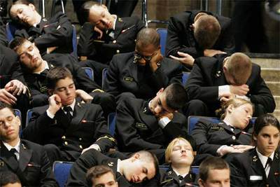 Cadetes de la Academia Naval de Annapolis dormitan mientras esperan la llegada del presidente George W. Bush.
