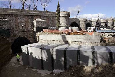 En primer plano, un operario junto el colector de aguas sucias, de tres metros de altura, que el Ayuntamiento pretende hacer pasar bajo el puente.
