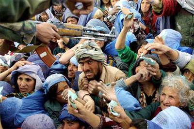 Un grupo de afganos trata de conseguir comida en un centro de distribución de Kabul en 2001.