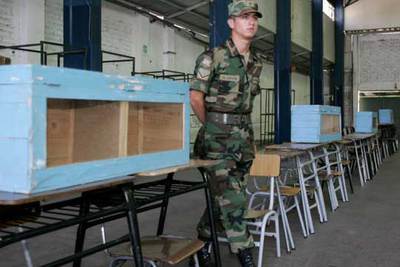 Un soldado vigila las urnas de un centro electoral de Santiago de Chile dispuestas para las elecciones de mañana.