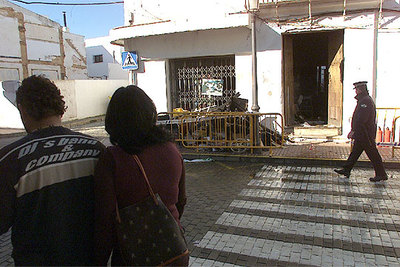 Unos vecinos de Cartaya, ayer, ante la casa incendiada en la que murió una anciana.