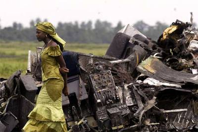 Una mujer camina entre los restos del avión que se estrelló el sábado cerca de Port Harcourt.